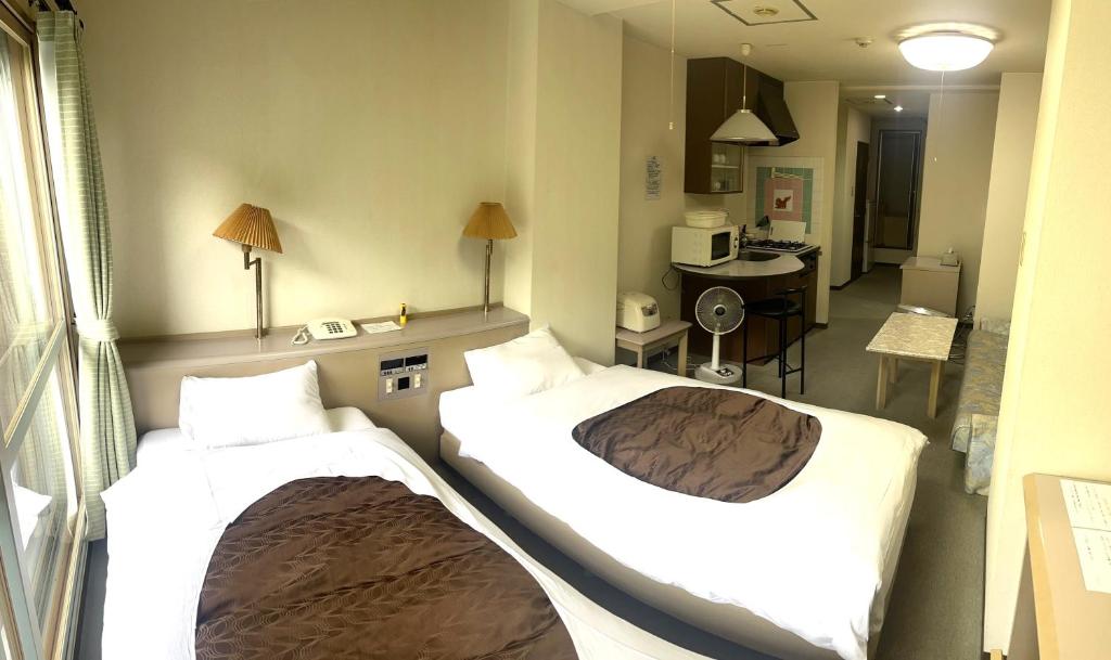 um quarto de hotel com duas camas num quarto em フューデイズコンドミニアム定山渓106号室 em Jozankei