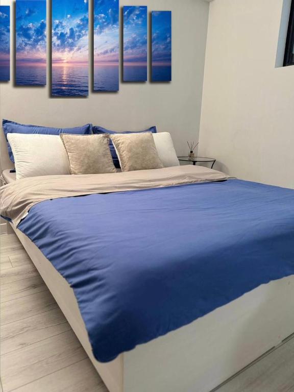 - une chambre avec un lit et une couverture bleue dans l'établissement Апартаменты от BVO Group, à Almaty