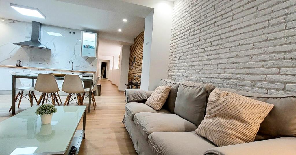 a living room with a couch and a brick wall at Holiday Hanna’s House in Valencia