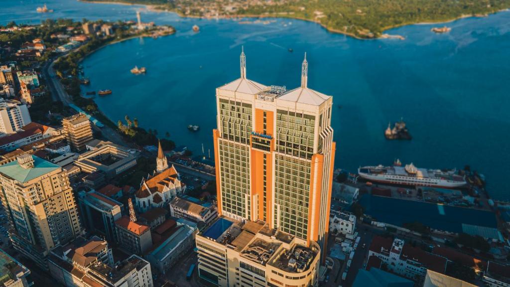 una vista aérea de un edificio alto con luz naranja en él en Johari Rotana en Dar es Salaam
