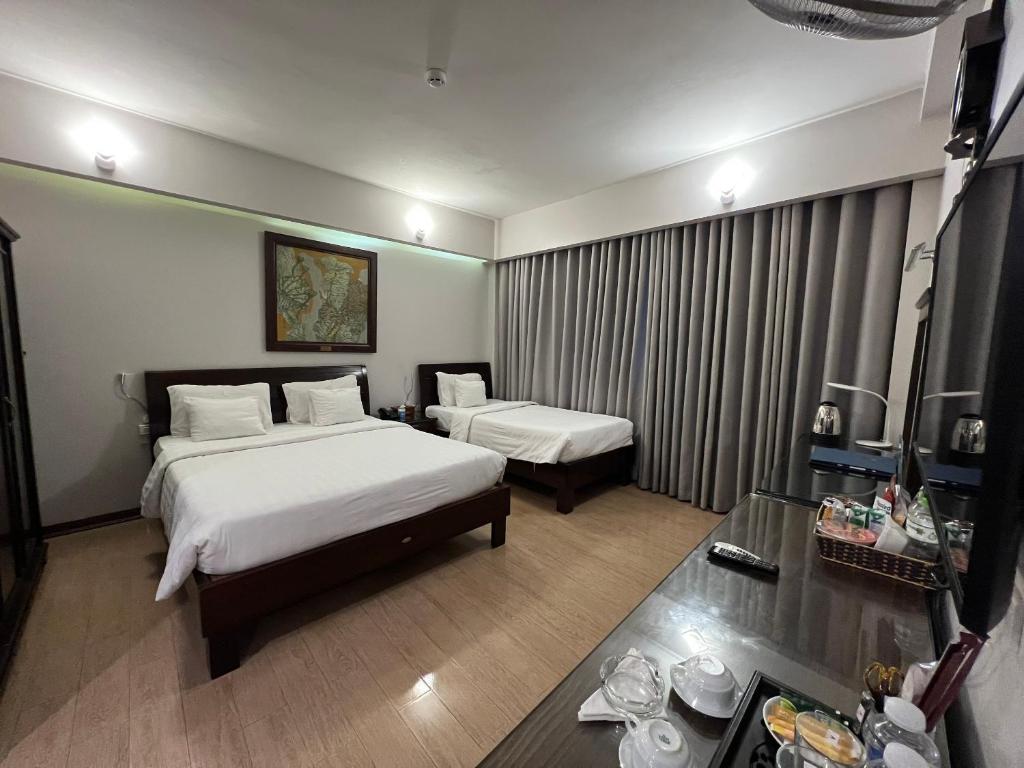 a hotel room with two beds and a table at A25 Hotel - 88 Nguyễn Khuyến in Hanoi