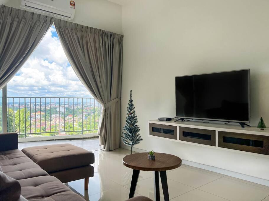 a living room with a flat screen tv on a wall at Taiping City View Condo near Lake Garden/ Netflix in Taiping