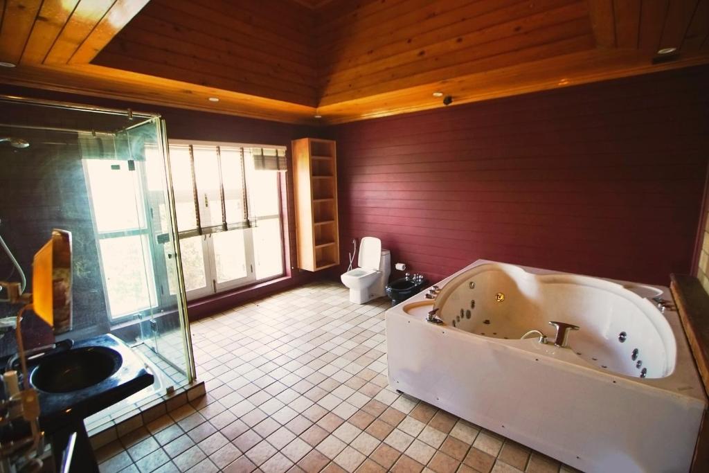 a large bathroom with a tub and a toilet at The GoodFind Residency in Srinagar