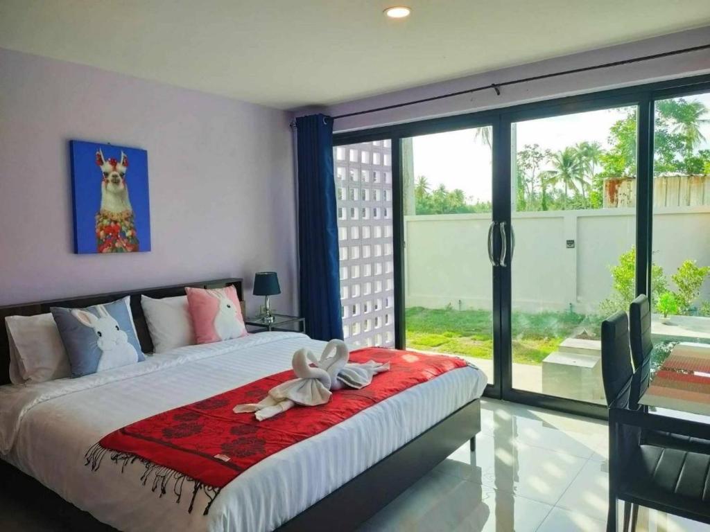 un dormitorio con una cama con un animal de peluche en บ้านคุณพระ แอท รพ.กรุงเทพ en Surat Thani