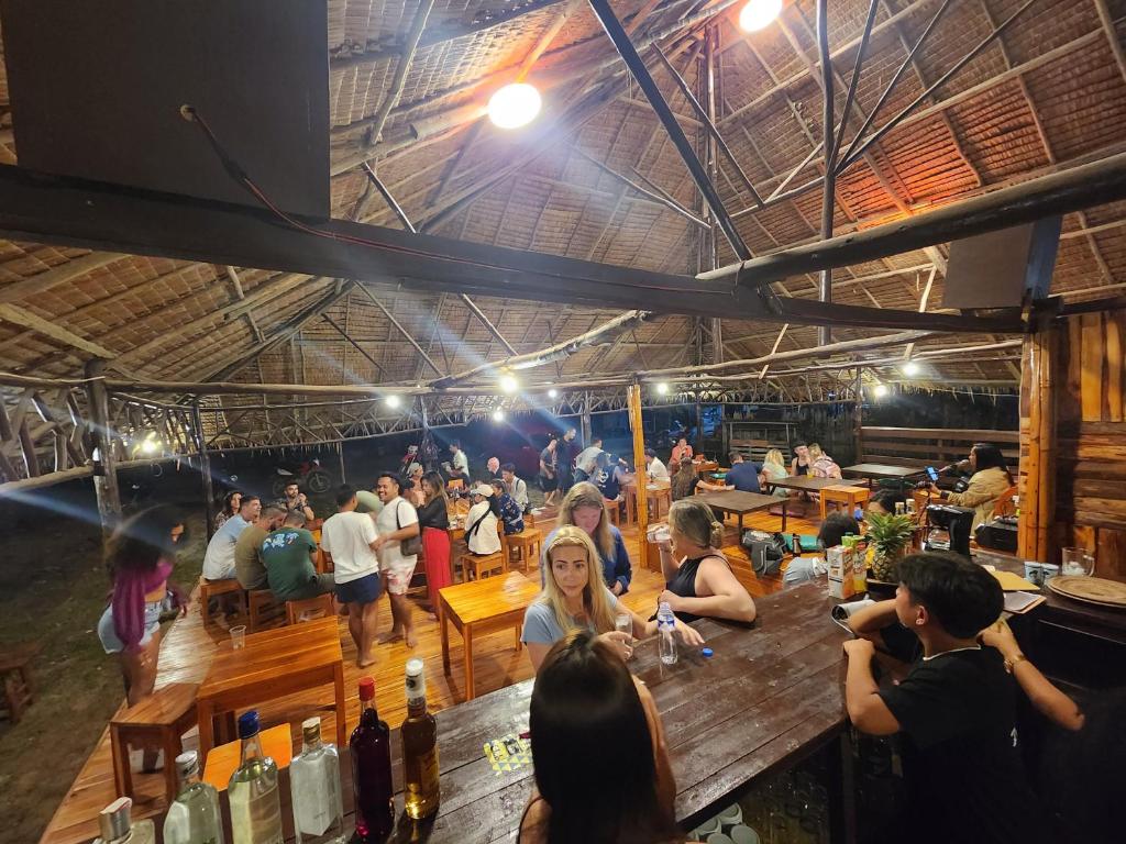 Une foule de personnes assises à des tables dans un bar dans l'établissement Dam Dam Hostel, à San Vicente