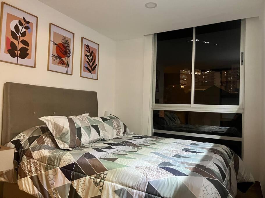 a bedroom with a bed in front of a window at Moderno Apartamento en el Centro in Bogotá