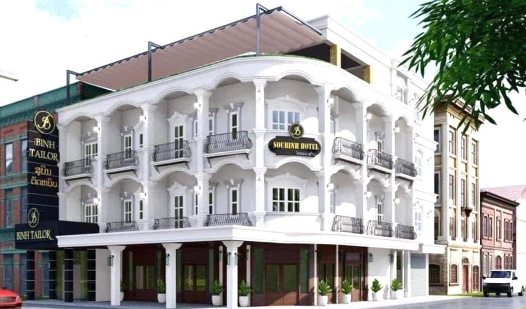 un gran edificio blanco en la esquina de una calle en SUBINH HOTEL AND RESTAURANT en Pakse