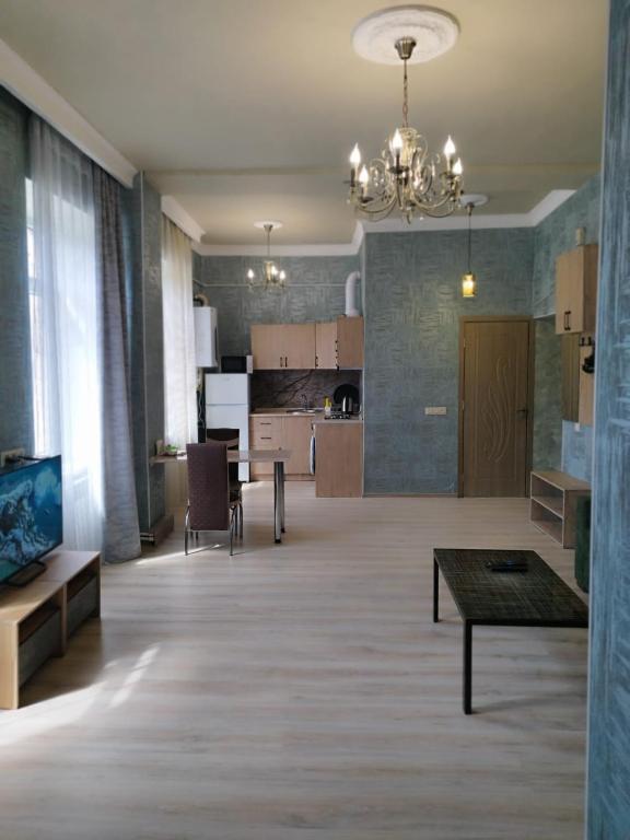 ein großes Wohnzimmer mit einem Tisch und einer Küche in der Unterkunft Апартаменты -студия in Vanadzor