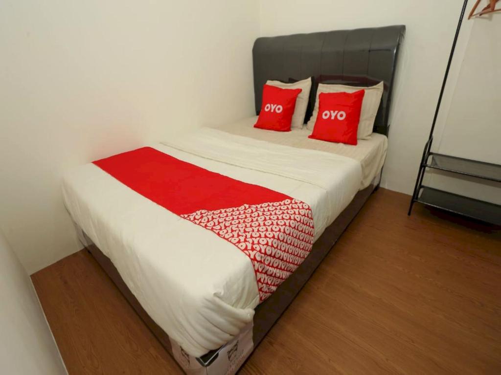 a bedroom with a bed with two red pillows at Capital O 93261 Fresh Hotel Near Stasiun Jakarta Kota in Jakarta