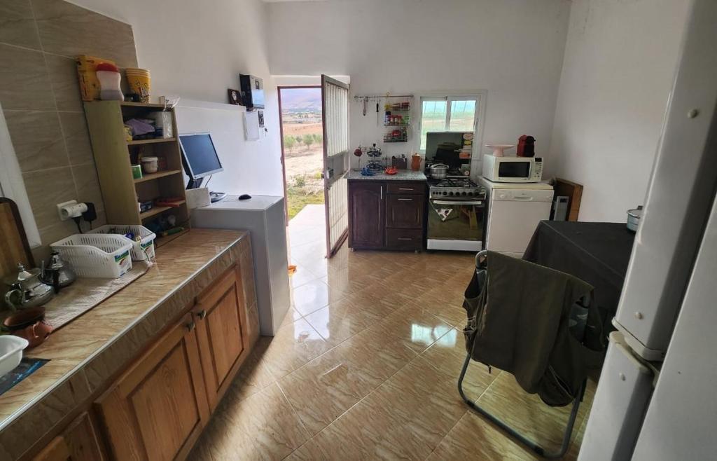 a kitchen with a counter and a kitchen with a refrigerator at Ferme Jnan Al Yassmine in Taza