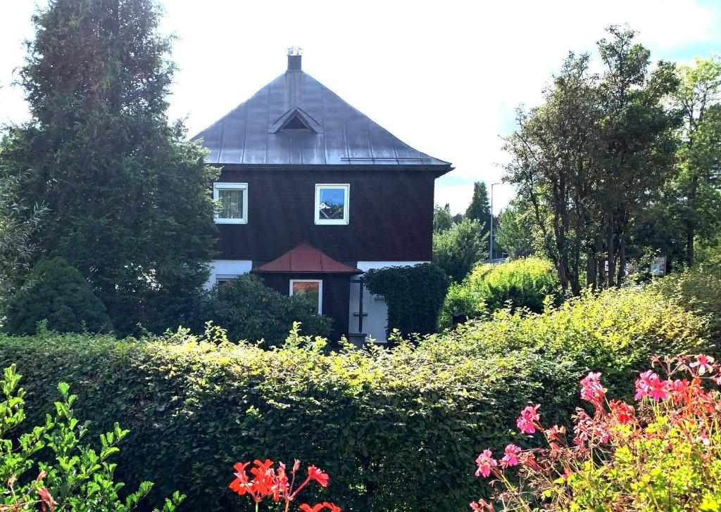 a black house with a black roof and a garden at Ferienwohnung "Fichtelnaabrauschen" in Fichtelberg