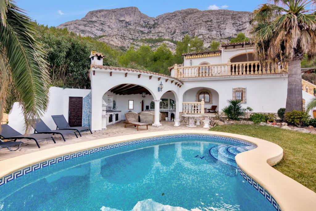 a pool in front of a house with a mountain at Villa Lau Costa Blanca in Denia