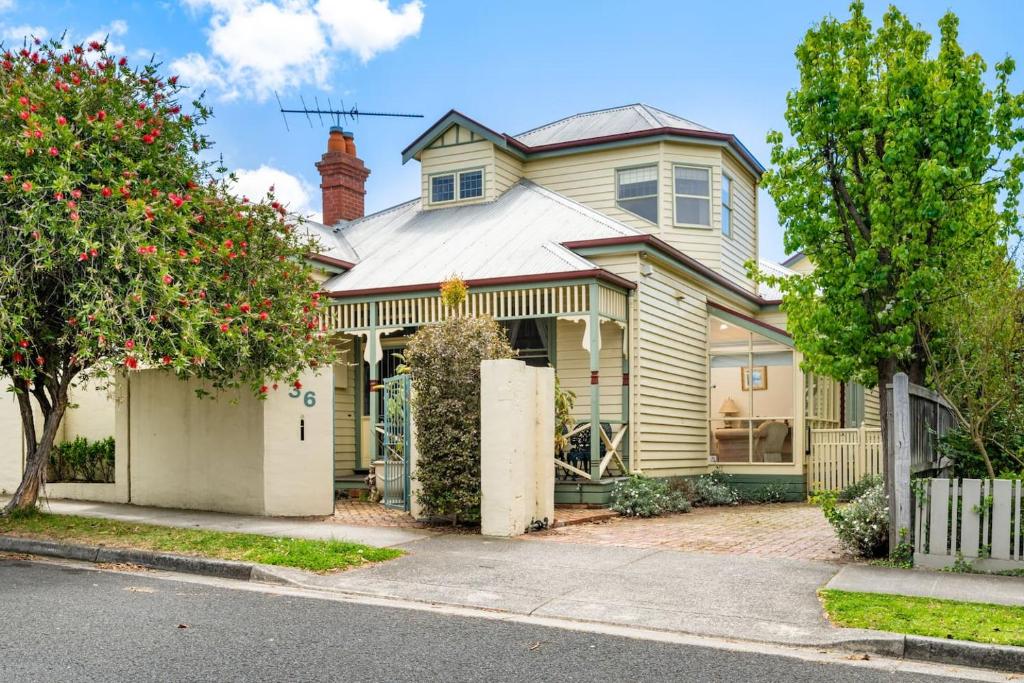 una casa amarilla con una puerta delante de ella en Heritage on Fairview - Classic Comfort in Geelong en Geelong