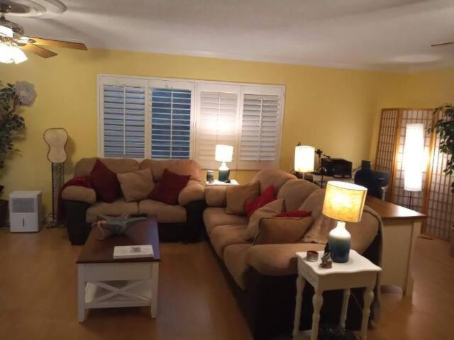 ein Wohnzimmer mit einer Couch und zwei Tischen in der Unterkunft Large Lush Oasis Paradise by FLL Beach and Galleria - 2bd 2ba in Fort Lauderdale