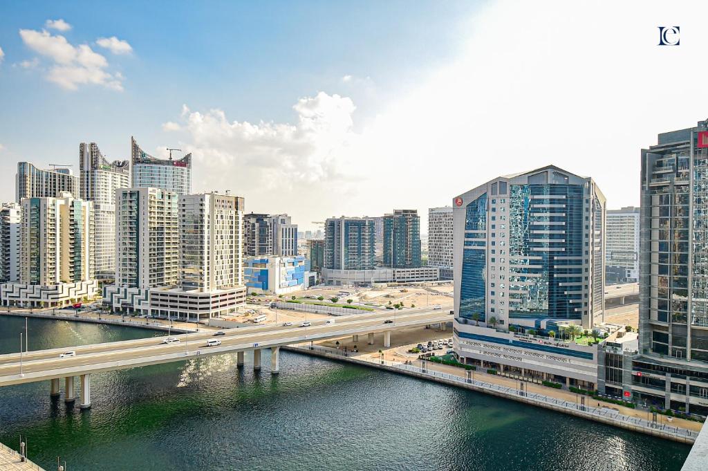a city with a bridge over a river and buildings at Canal View Studio Apartments - DAMAC Prive Business Bay in Dubai