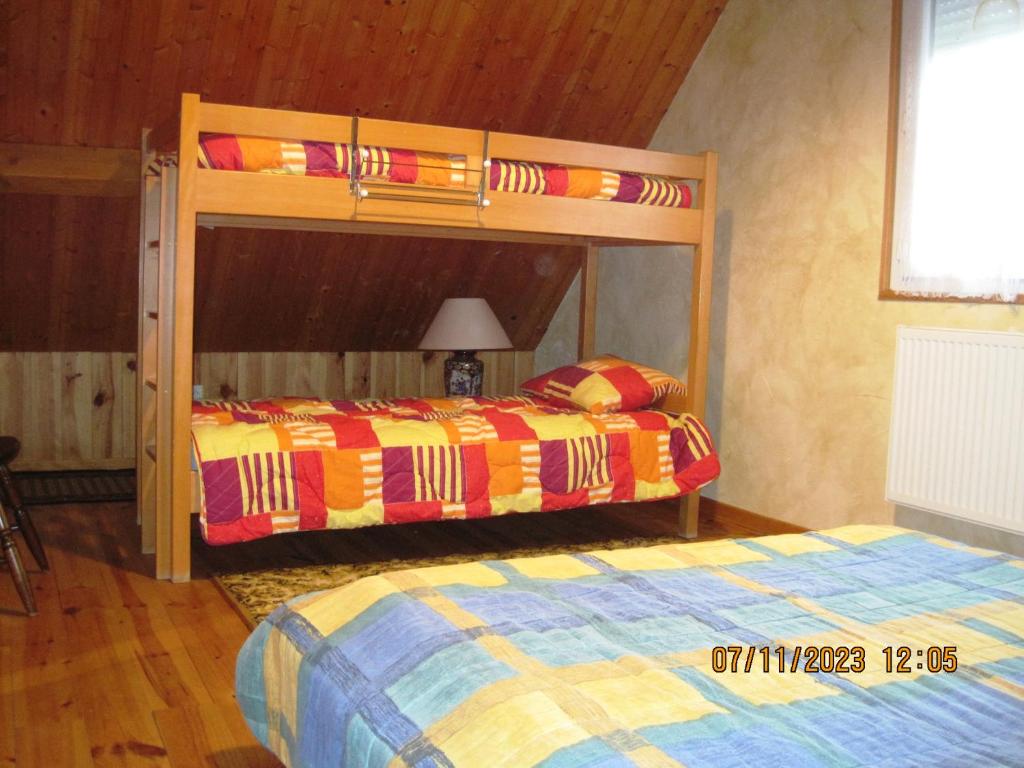 een slaapkamer met 2 stapelbedden en een bed bij 77 Rue de la Bresse in Nance