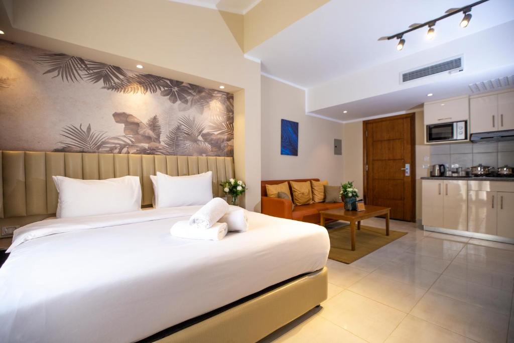 1 dormitorio con 1 cama blanca grande y cocina en Vibotel Residence en El Cairo