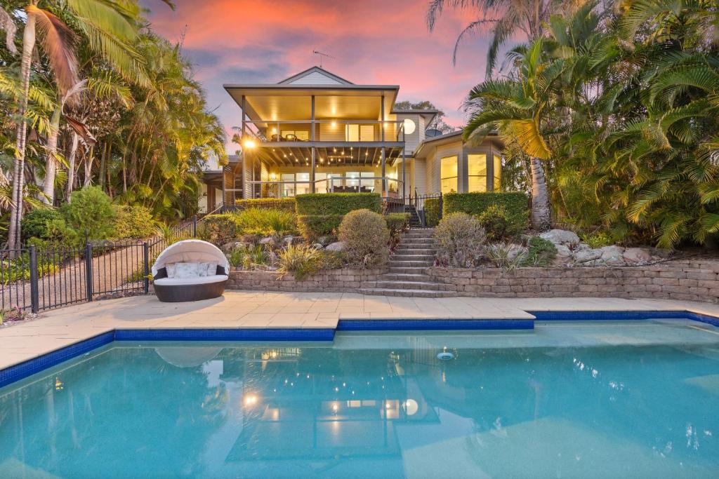 une maison avec une piscine en face d'une maison dans l'établissement Coco Palms, à Hervey Bay