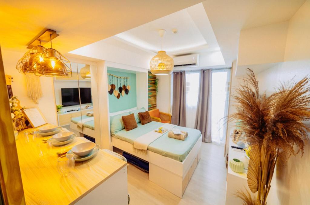 a large room with a bed and a dining table at Bohemian Coast at Azure North in Lagundi