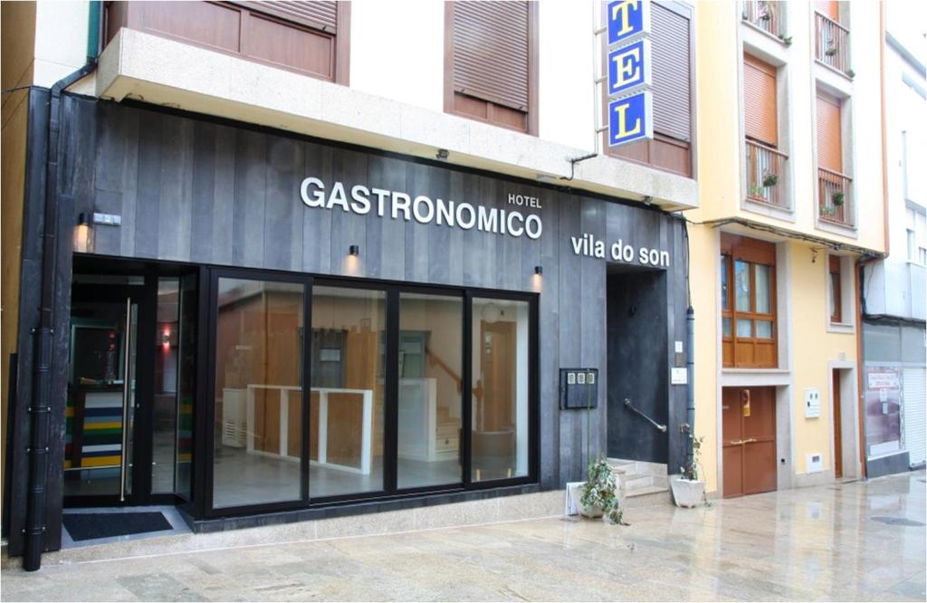 una tienda frente a un edificio con puertas de cristal en Hotel Villa del Son, en Porto do Son