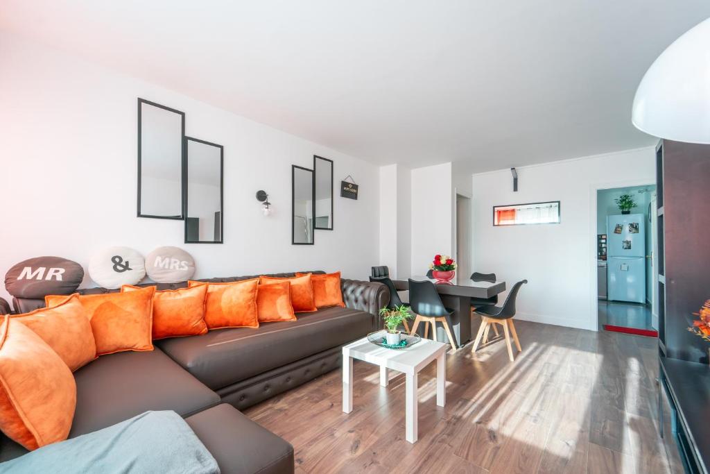 uma sala de estar com um sofá e uma mesa em Sunrise - Bel apt 2 chambres em LʼHay-les-Roses