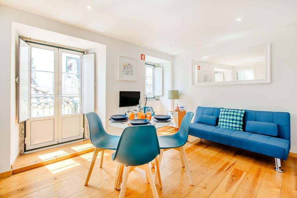 a living room with a blue couch and a table at Alfama Charming Apartment in Lisbon