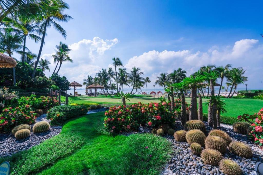 a garden with palm trees and plants and flowers at Xtu 2Bedrooms at Forest City民宿 in Gelang Patah