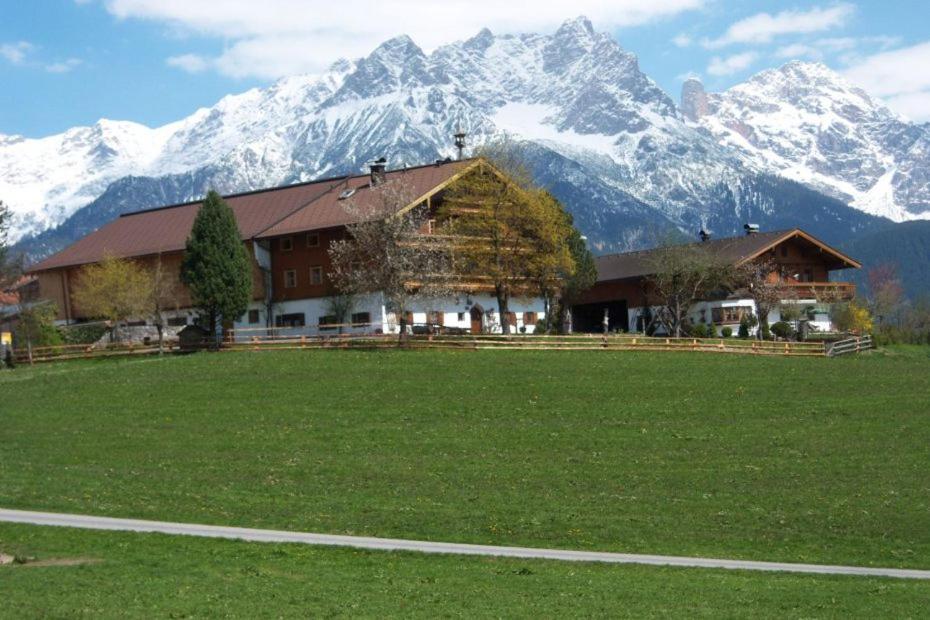 un gran edificio frente a una montaña en Pension Schmiderer - Vorderkasbichlhof, en Saalfelden am Steinernen Meer