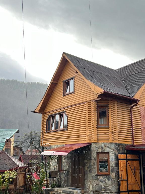 una casa de madera con techo negro en Cottage u Romana, en Yaremche