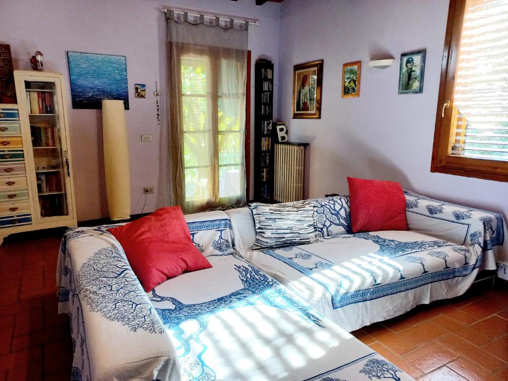 uma sala de estar com um sofá e almofadas vermelhas em Casa Gelso em Scandicci