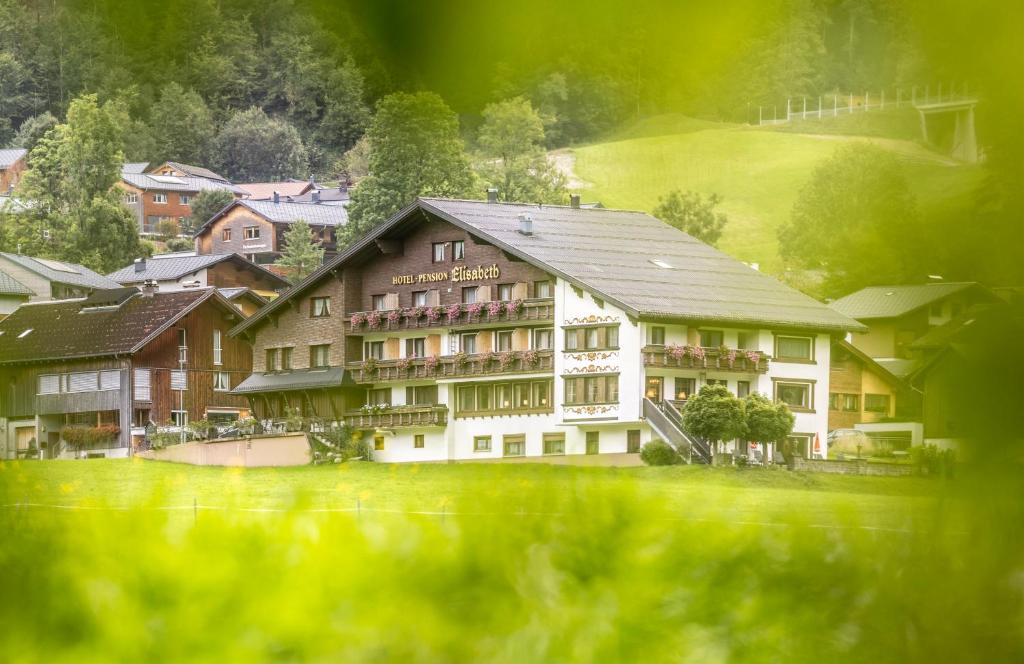 een groot gebouw midden in een dorp bij Hotel Elisabeth in Schoppernau