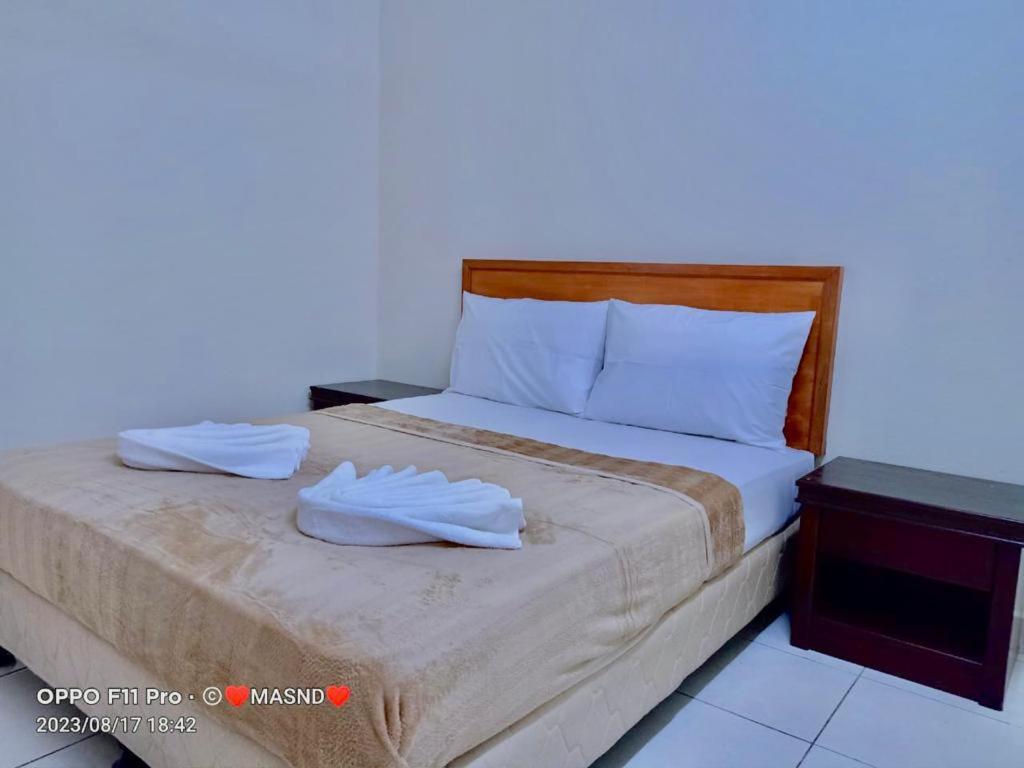 ein Schlafzimmer mit einem Bett mit zwei Handtüchern darauf in der Unterkunft Tunas Cottage 2 in Kuah