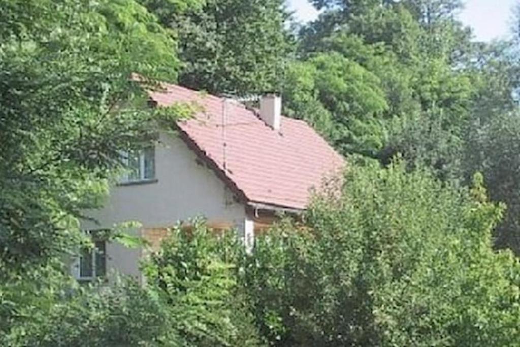 ein Haus mit rotem Dach in den Bäumen in der Unterkunft Maison Sur 2 Niveaux in Nance