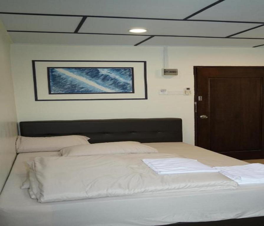 una camera da letto con un grande letto con lenzuola bianche di OYO 90876 Yss Homestead a Perai