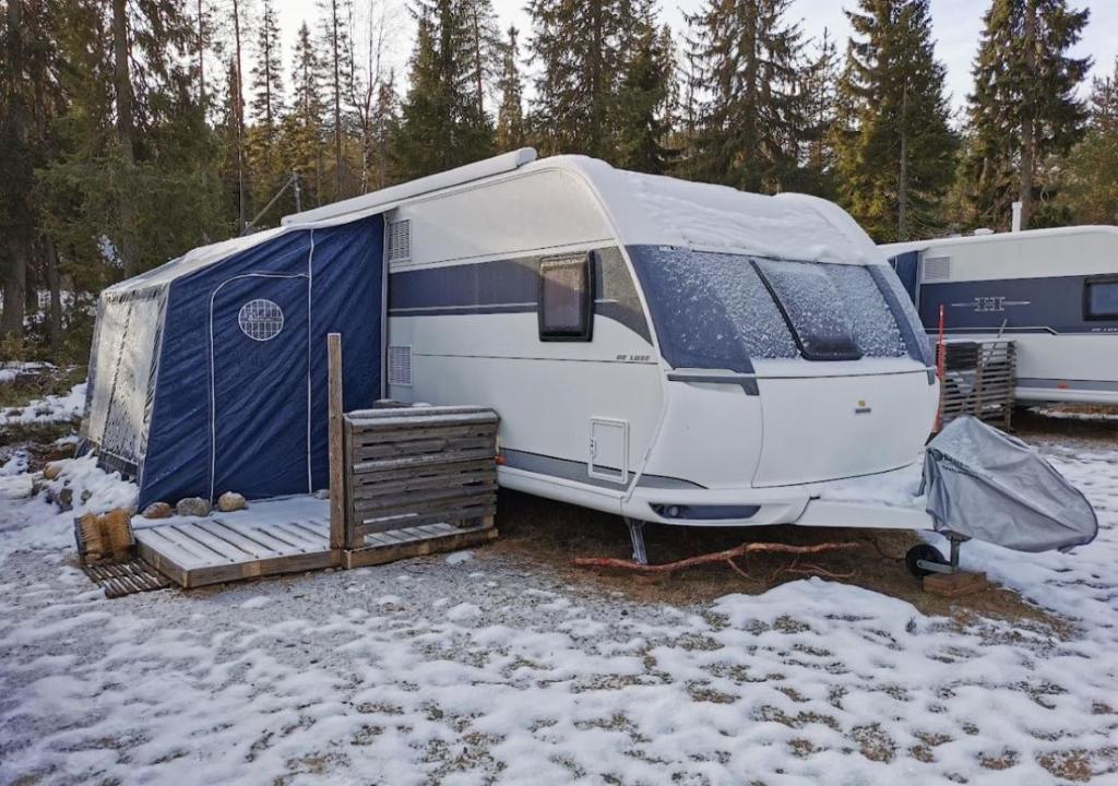 a white and blue trailer parked in the snow at Asuntovaunu Hobby in Syöte