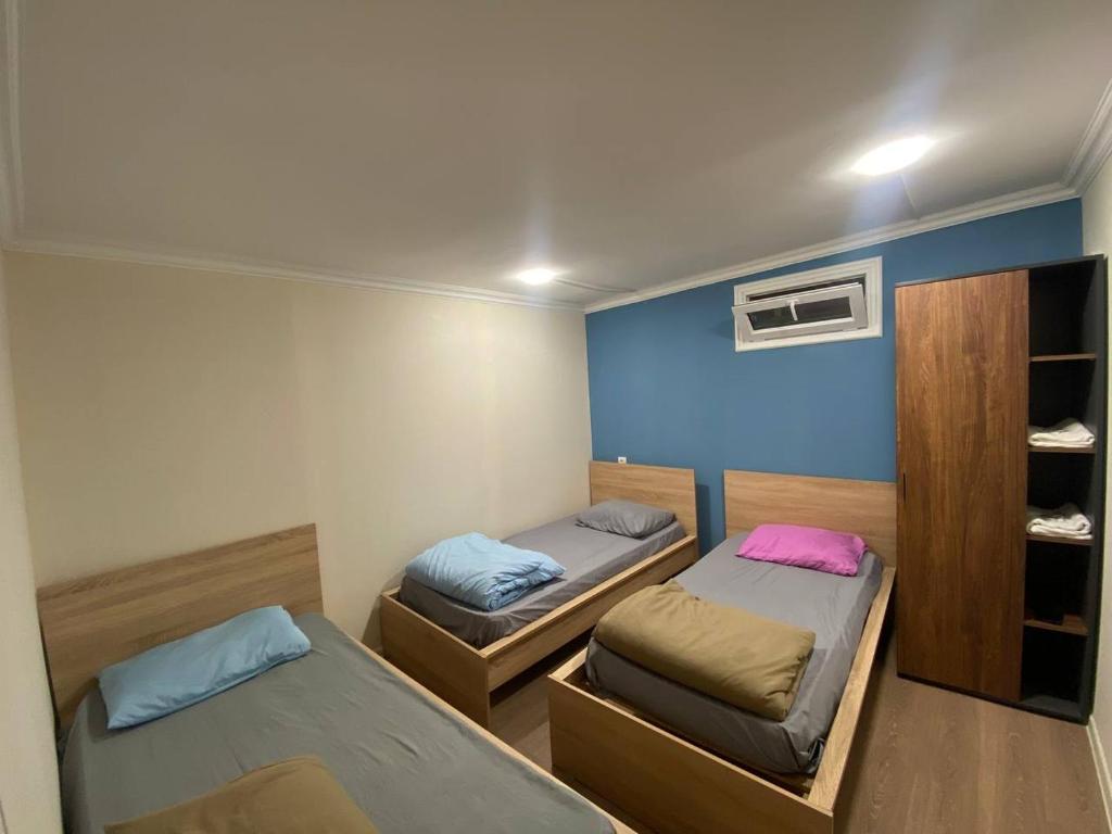 a bedroom with two beds and a blue wall at Paronyan hostel in Yerevan