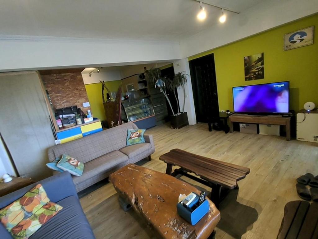 a living room with a couch and a tv at Blackport Seaview Homestay in Yanliau