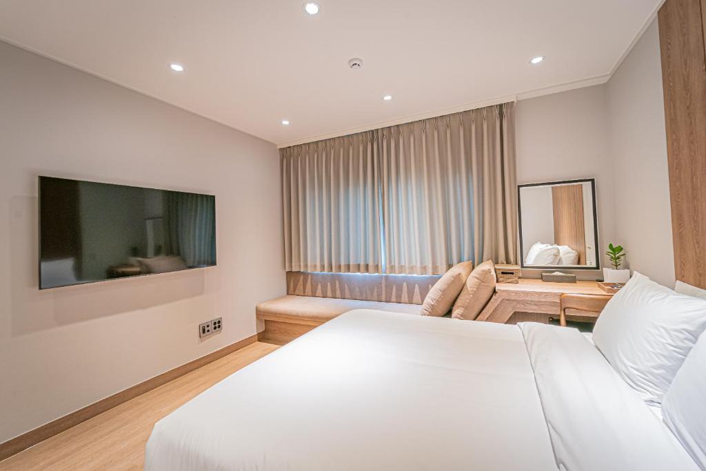 ein Hotelzimmer mit einem Bett und einem Tisch in der Unterkunft The Private Hamdeok in Jeju-do