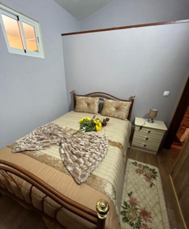ein Schlafzimmer mit einem Bett mit Blumen darauf in der Unterkunft O Recanto do Sossego in Mértola
