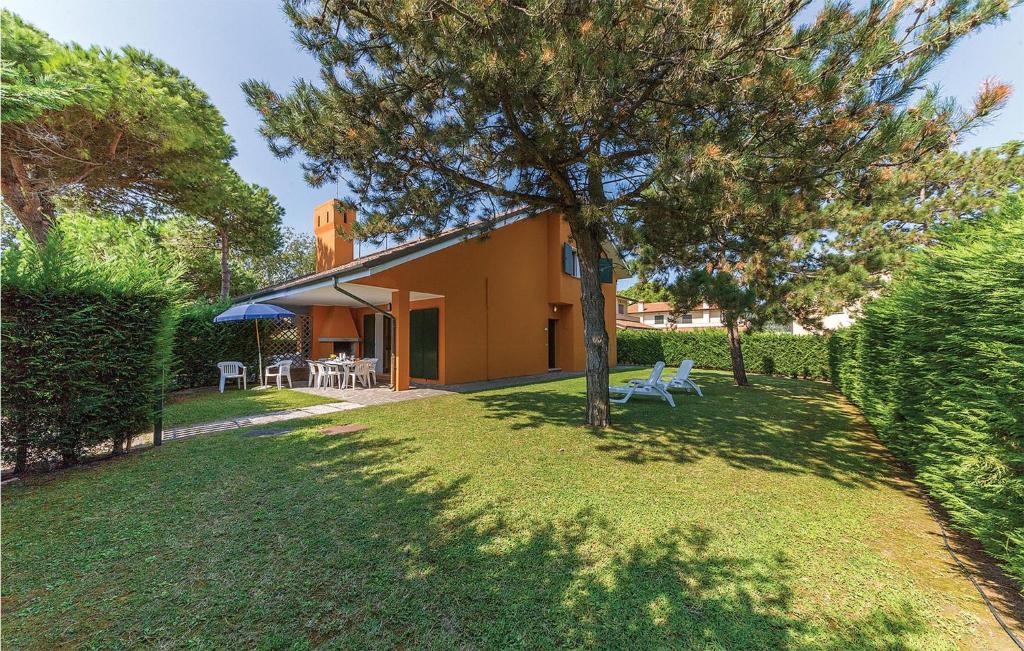 una casa con un árbol en el patio en S2 Conchiglia, en Isola Albarella
