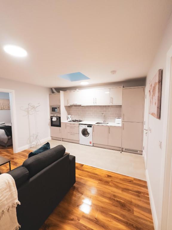 een woonkamer met een zwarte bank en een keuken bij Entire Cozy Guest house in Galway