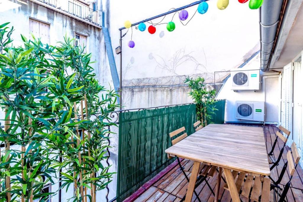 uma pequena varanda com uma mesa de madeira na varanda em Canebière 3 // Bel appartement climatisé avec terrasse em Marselha