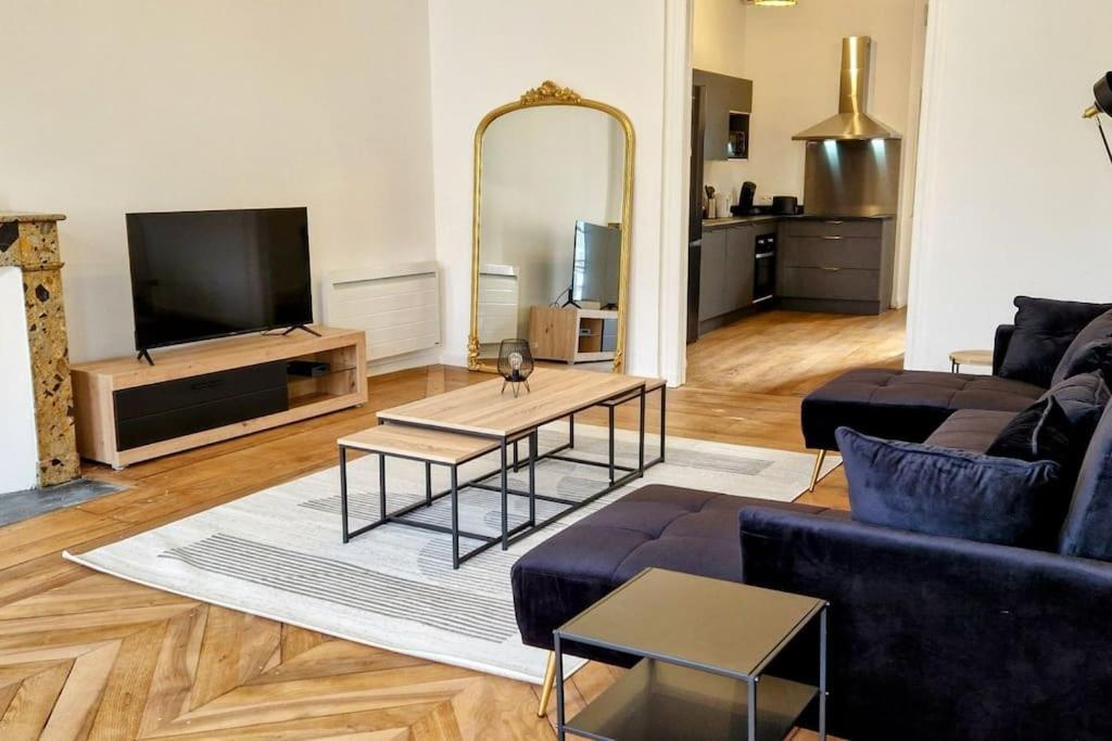 un salon avec un canapé et un grand miroir dans l'établissement La Parqueterie - 2 pas des thermes - 6 voyageurs, à Bagnères-de-Bigorre