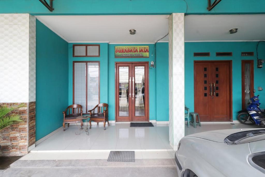 una camera con pareti blu e tavolo e sedie di Hotel Surabaya Jaya Bandara Soetta a Rawalembang