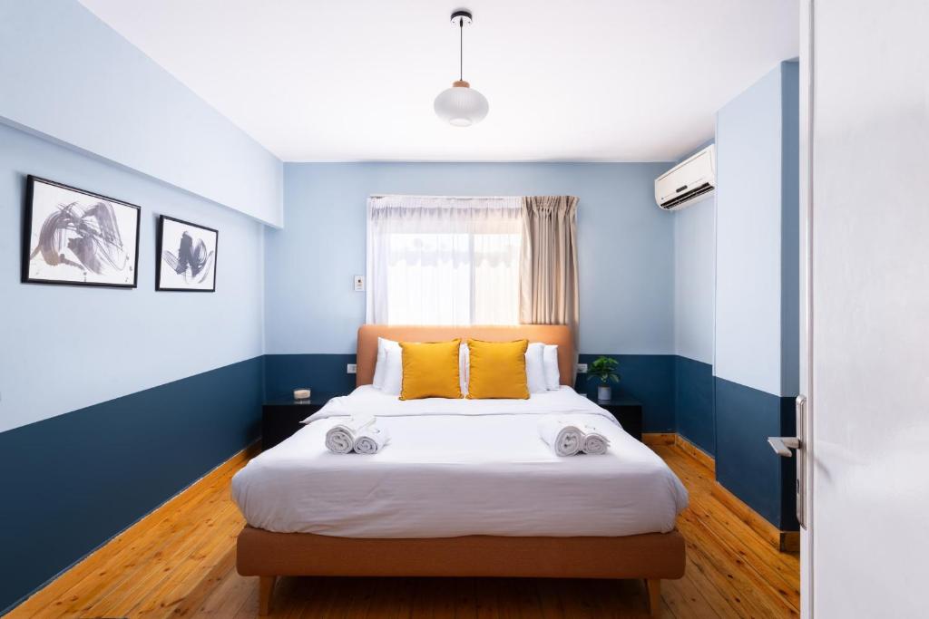 a bedroom with blue walls and a bed with yellow pillows at The 2 BDR Sterling Residence 5 min to CAI Airport in Cairo