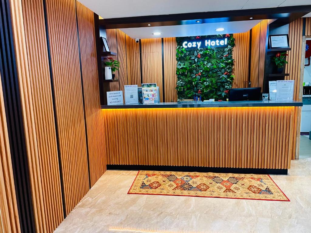 A timber-panelled reception desk with a hotel sign and guest information.