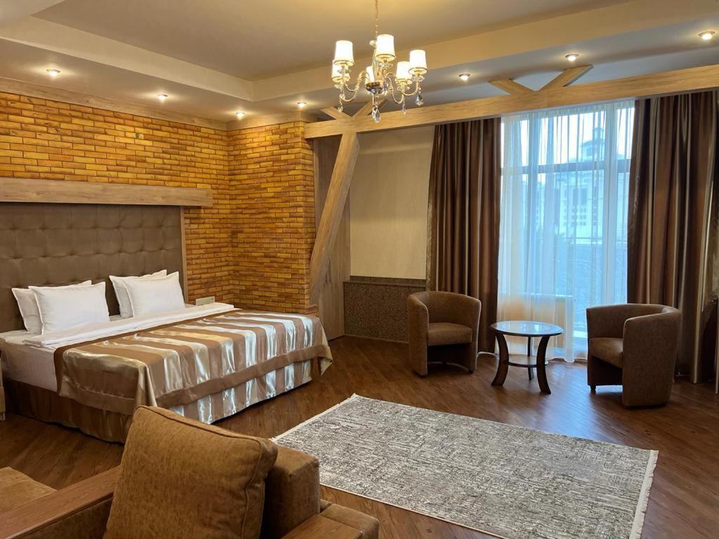 a hotel room with a bed and a table and chairs at CITY STAY Апарт-Отель Алматы in Almaty