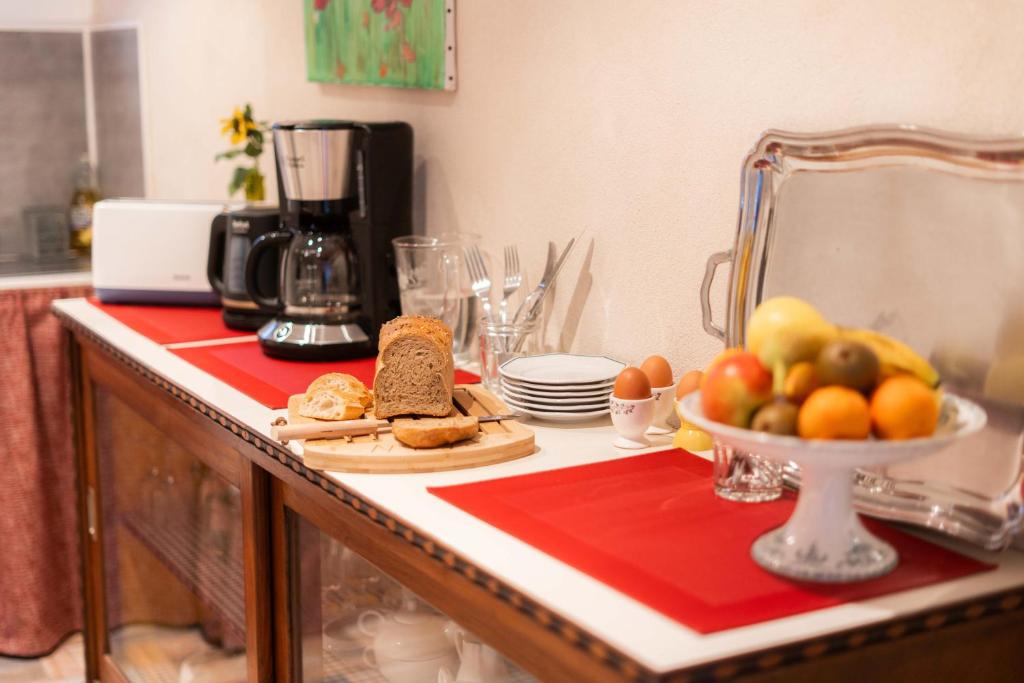 a kitchen counter with a plate of bread and fruit on it at Les Balcons sur la Loire in Chalonnes-sur-Loire