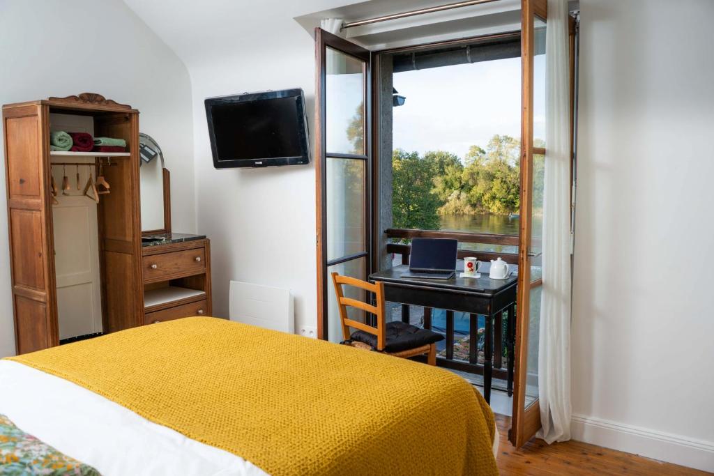 a bedroom with a bed and a desk and a window at Les Balcons sur la Loire in Chalonnes-sur-Loire