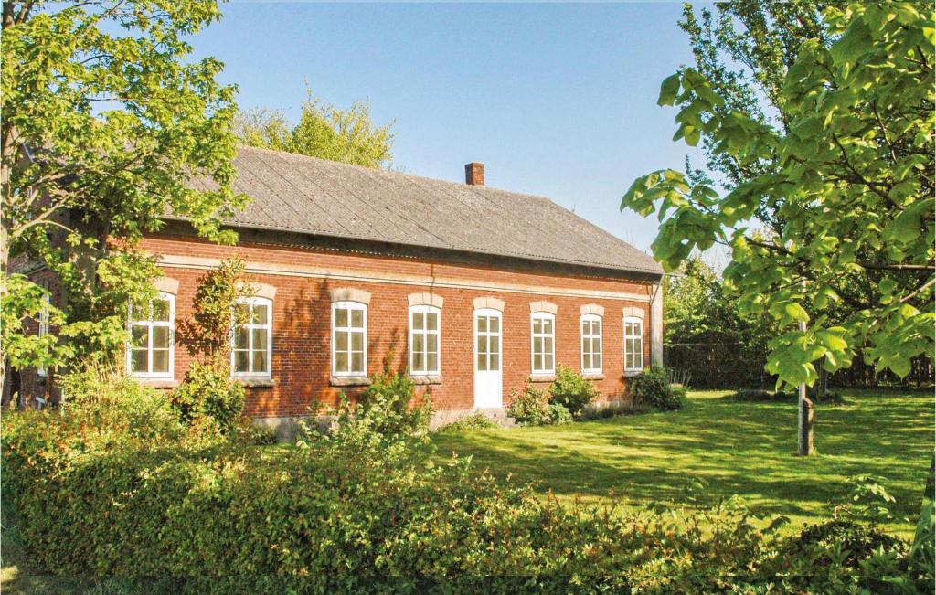 een oud rood bakstenen huis met witte ramen bij Cozy Home In Bredebro With Wifi in Bredebro